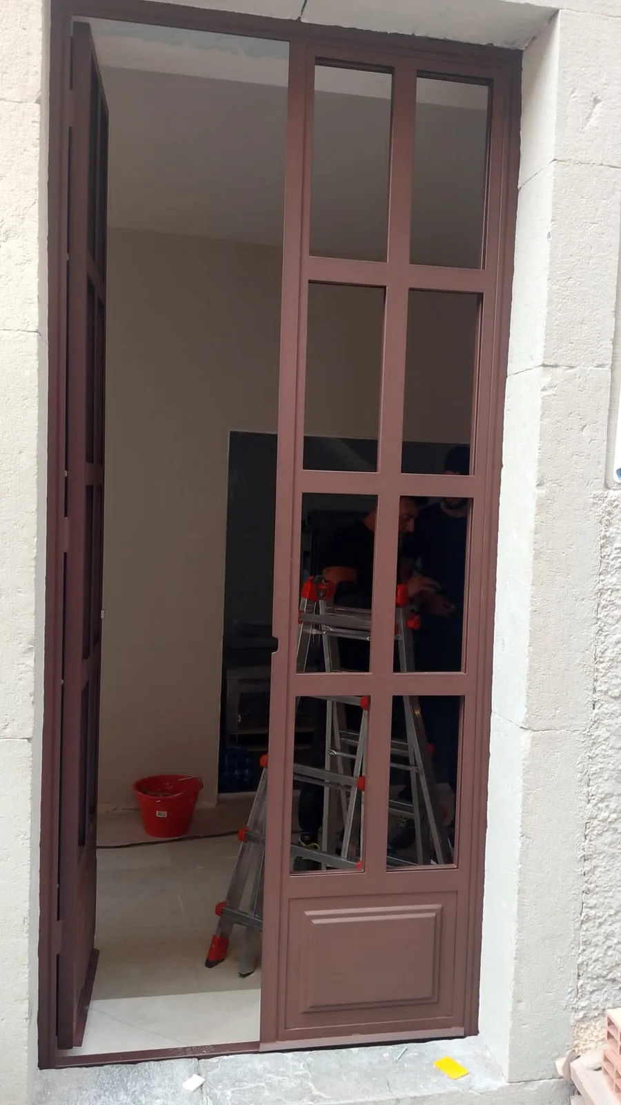 Porta vetrata su misura durante le fasi finali di posa
